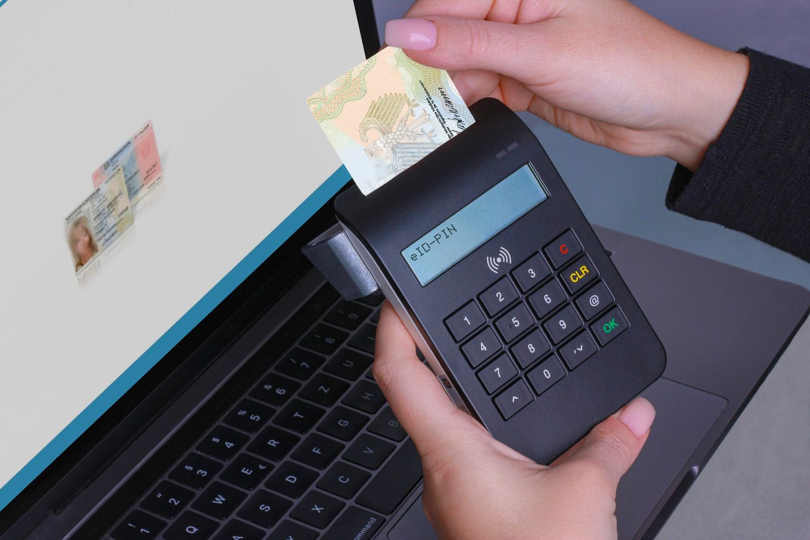 Hand steckt einen elektronischen Personalausweis in ein eID-Lesegerät mit PIN-Eingabe vor einem Laptop