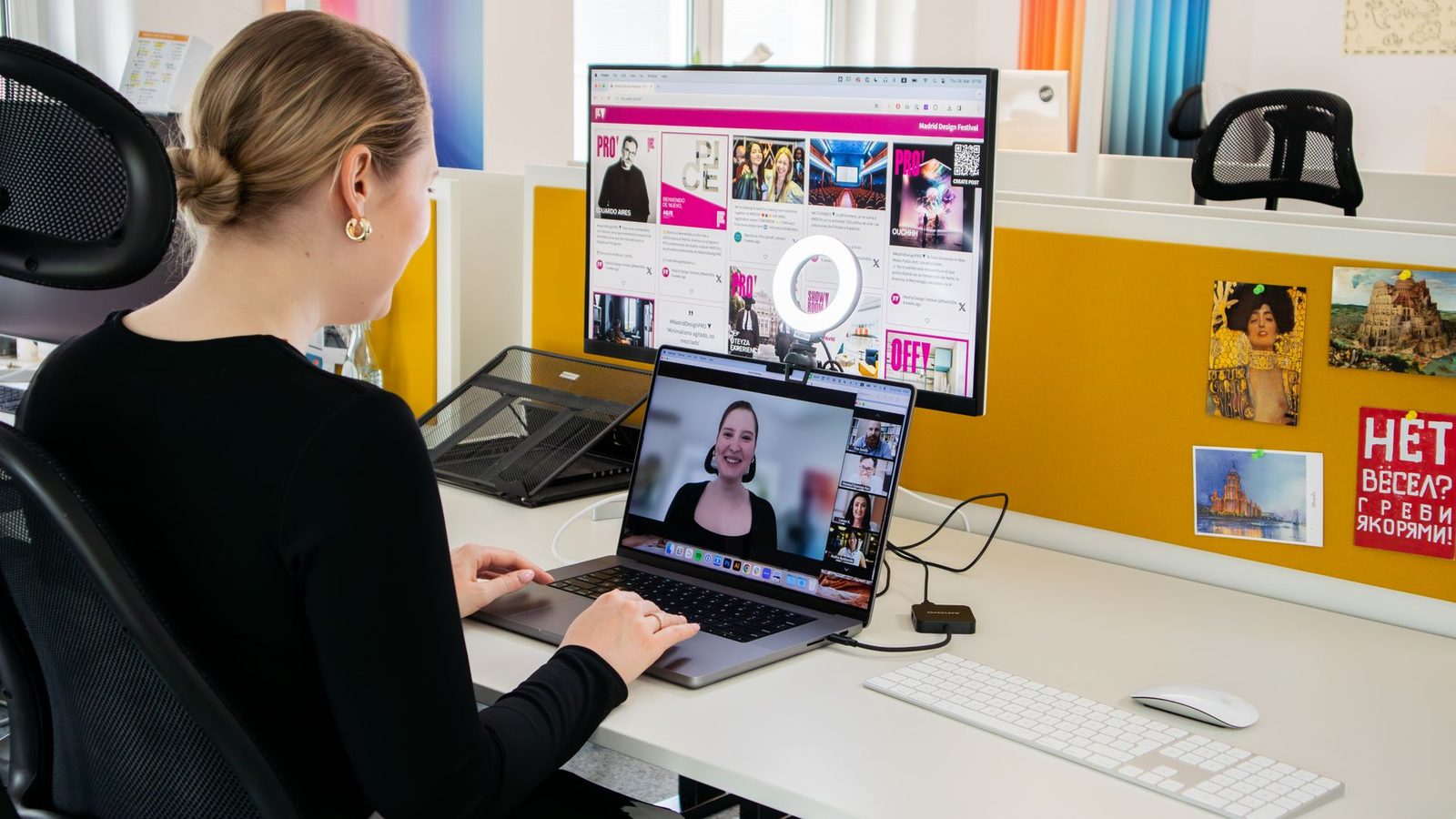 Woman sitting at a desk taking part in a video call on a laptop with a webcam