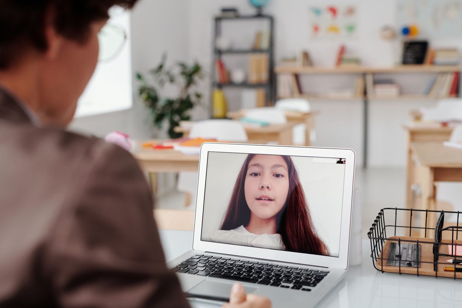 Persona davanti a un computer portatile in videochiamata con una ragazza visualizzata sullo schermo